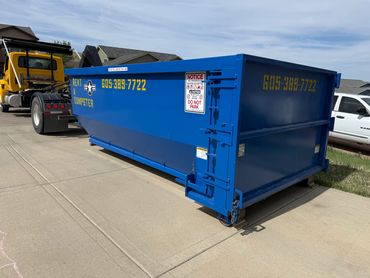 Dumpster with wood to protect driveways from damage.