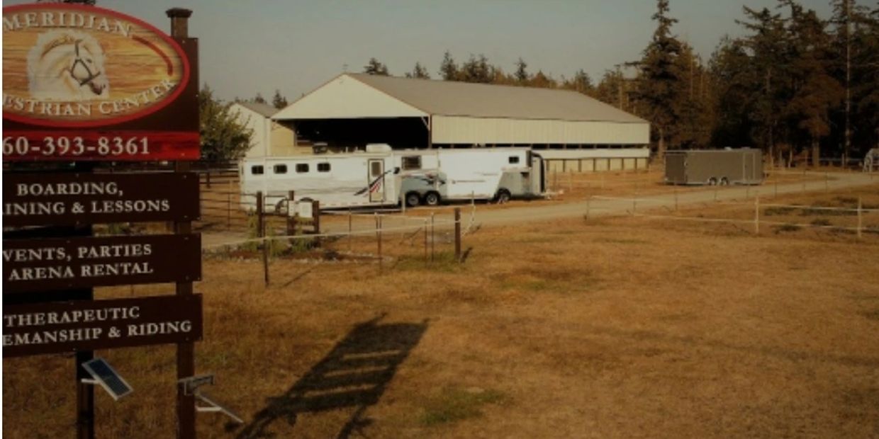 Equestrian center with trailers and a barn.
