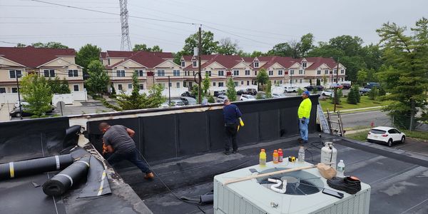 New roof being installed on a commercial building. Tear offs, torch down roofing, rubber roofing