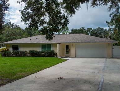Single-story house with a garage and large driveway.