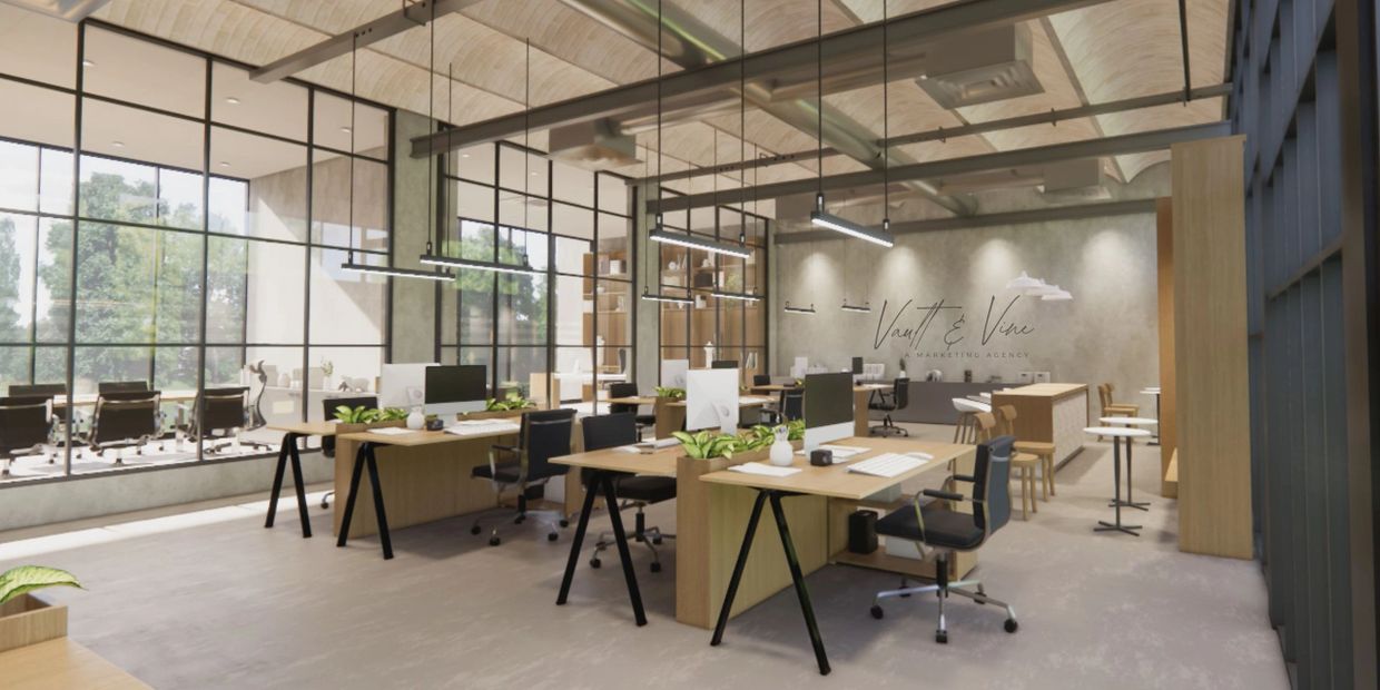 Modern open-plan office with wooden desks and large windows letting in natural light.