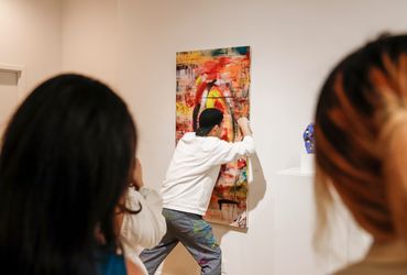 Artist modifying artwork during opening.
