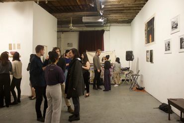 Spectators conversing and looking at artwork.