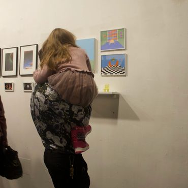 Someone carrying child so they can get a better view of artwork.