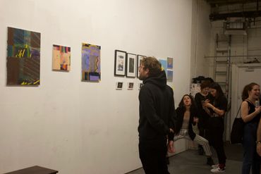 Spectators conversing and looking at artwork.
