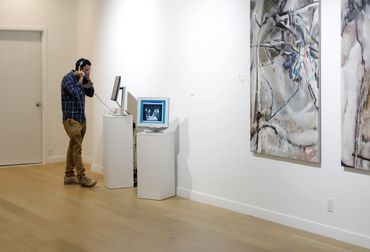 A man interacting with artwork by Sherly Fan.