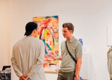 Two people talking about artwork.