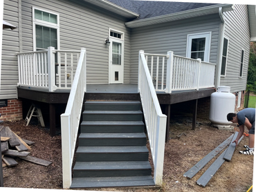 Newly constructed 400 sq ft. deck made of black compost wood and white railing.