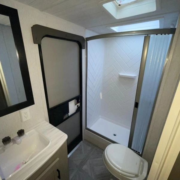 Photo showing spacious (by travel trailer standards) bathroom...complete with a medicine cabinet too