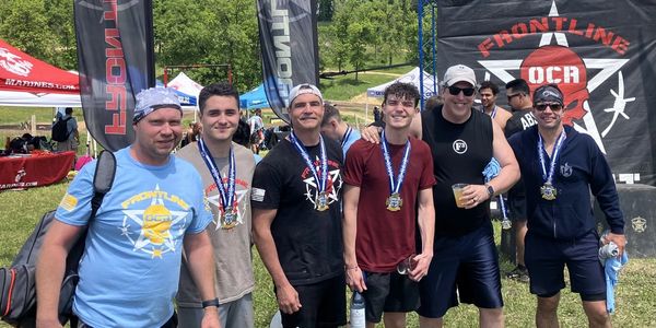 A group of finishers wearing medals at a Frontline OCR obstacle course race