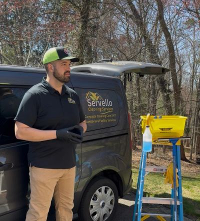 commercial cleaning business owner standing next to branded van in uniform