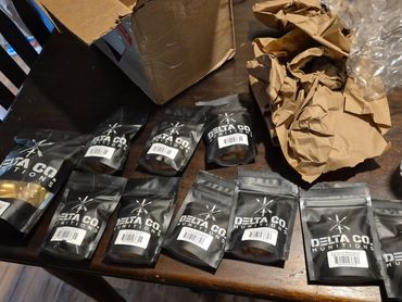 Various small black packages labeled 'Delta Co Munitions' on a wooden table.
