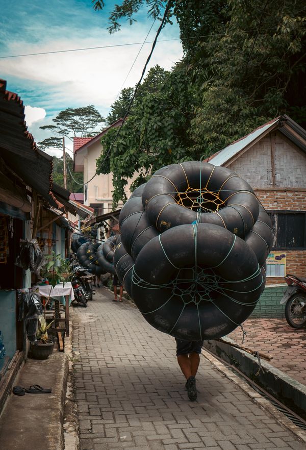 Guide carrying the tubes for rafting in Bukit Lawang