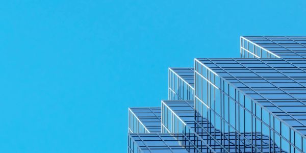 Modern glass skyscraper against a clear blue sky.