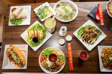 A vibrant spread of Vietnamese dishes on a wooden table.