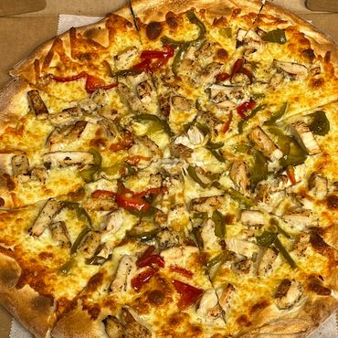 Grilled chicken pizza with green and red bell peppers in a box.