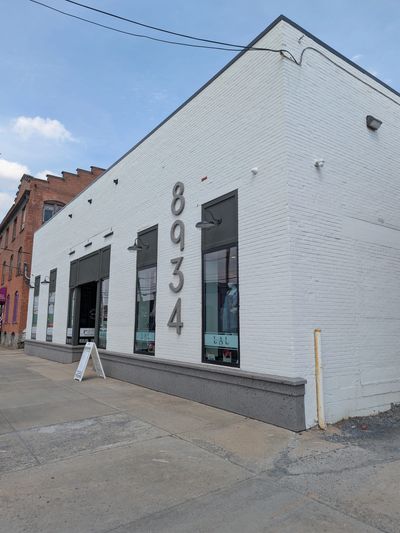 White brick commercial building with large numbers 8934 on the side.