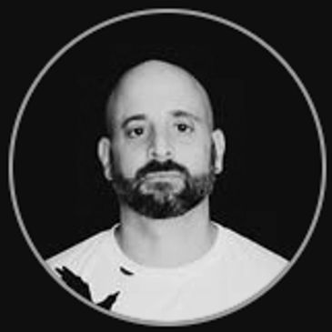 Black and white portrait of a bald man with a beard.