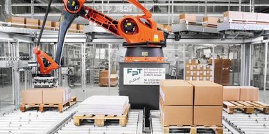 Automated robotic arm handling packages on conveyor belts in a modern warehouse.