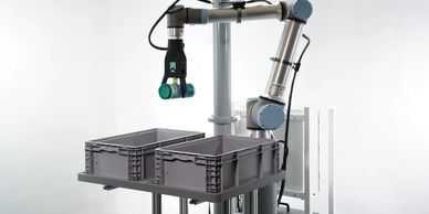 A robotic arm picking up a can and placing it into a bin.