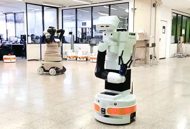 Robots with articulated arms navigate a modern office space with glass walls.