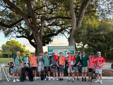 Group of men in colorful golf shirts posing at Emerald Hills golf club.