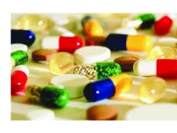 Various colorful pharmaceutical capsules and tablets scattered on a surface.