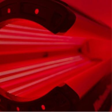 Close-up of a red tanning bed's interior.