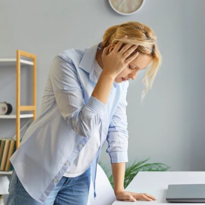 A woman feeling stressed and overwhelmed at work.