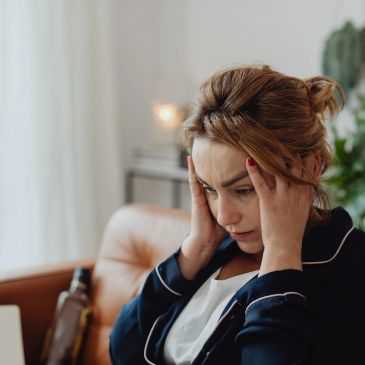 Woman feeling stressed and holding her head.