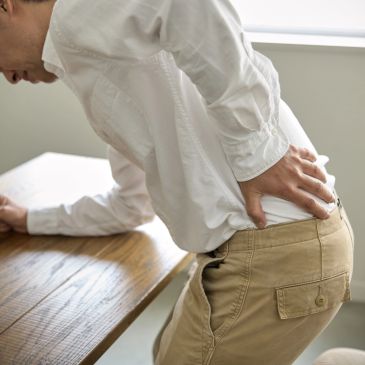 Person holding their lower back in pain.