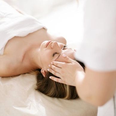 Woman receiving a gentle facial massage.