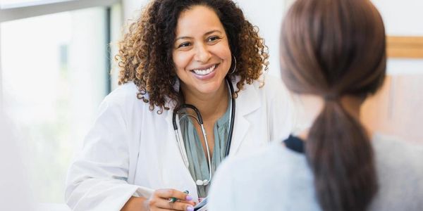 Smiling female doctor consulting with a patient in a bright office.