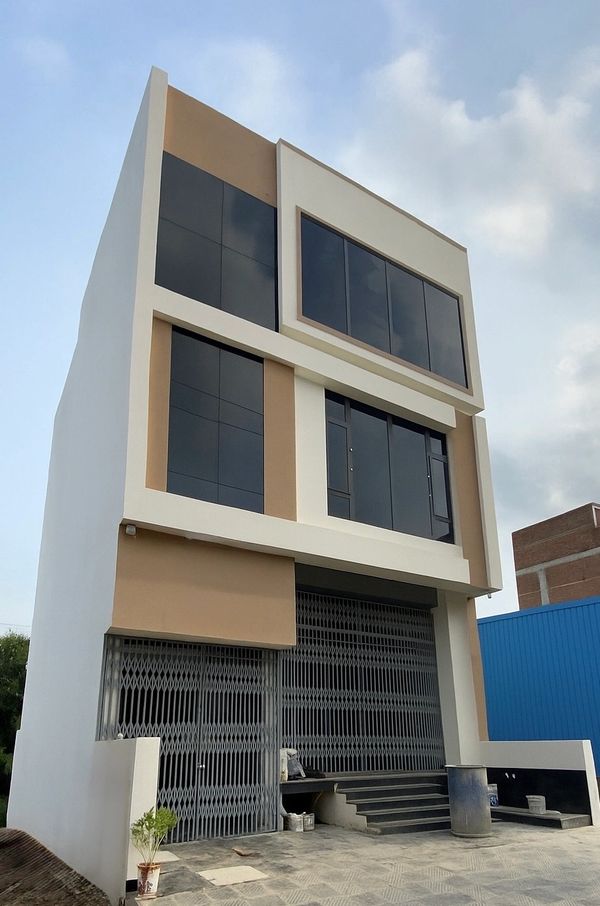 Modern three-story building with large tinted windows and metal gates.
