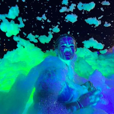 Young lady covered in green glowing foam.