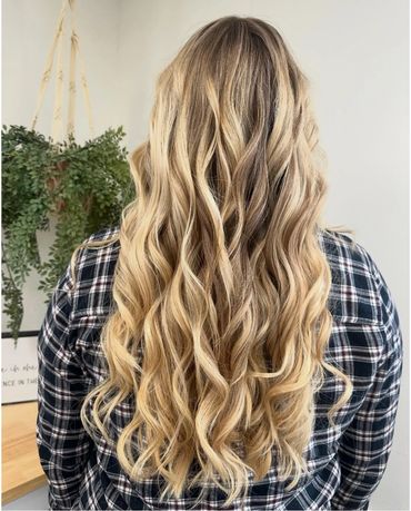 the back of a girls hed that recently had her hair styled and colored blonde inside a hair salon
