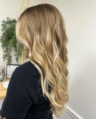 a side profile picture of a girl with blonde hair taken in the corner of a salon