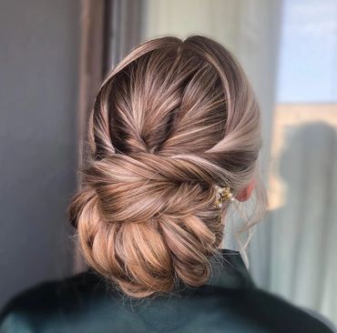 the back of a girls head that has an updo that looks like shes going to get married