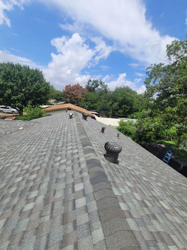 View of a rooftop with vents under a partly cloudy sky.