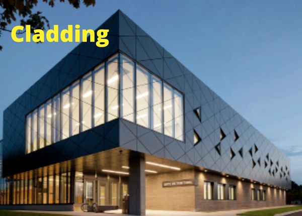 Modern building with geometric cladding and large glass windows lit from inside.