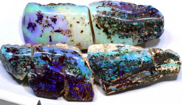 Four iridescent opal stones with blue, green, and brown hues.