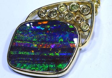 A gold pendant with a vibrant opal and diamond accents.