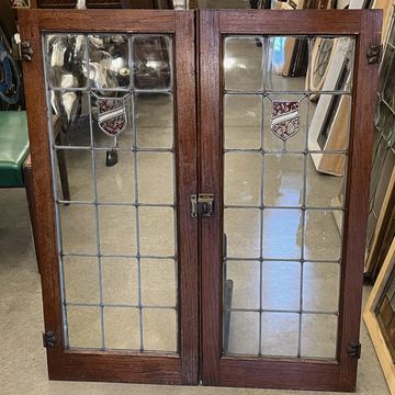 Pair of Tudor style antique cabinet doors circa 1920s with red stained glass shield