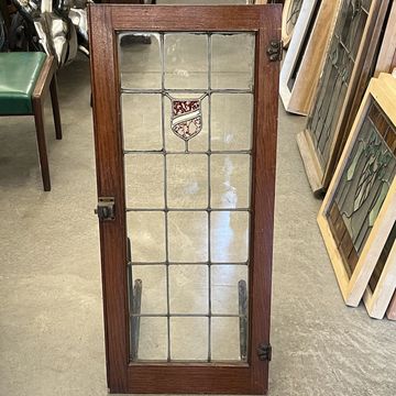 Single Tudor style antique cabinet doors circa 1920s with red stained glass shield