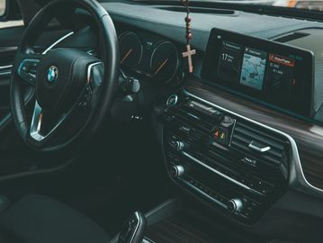 Interior of a BMW car showing steering wheel and dashboard.