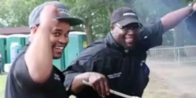 Two men smiling and gesturing outdoors.