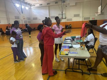 Community event in gym distributing school supplies to kids.