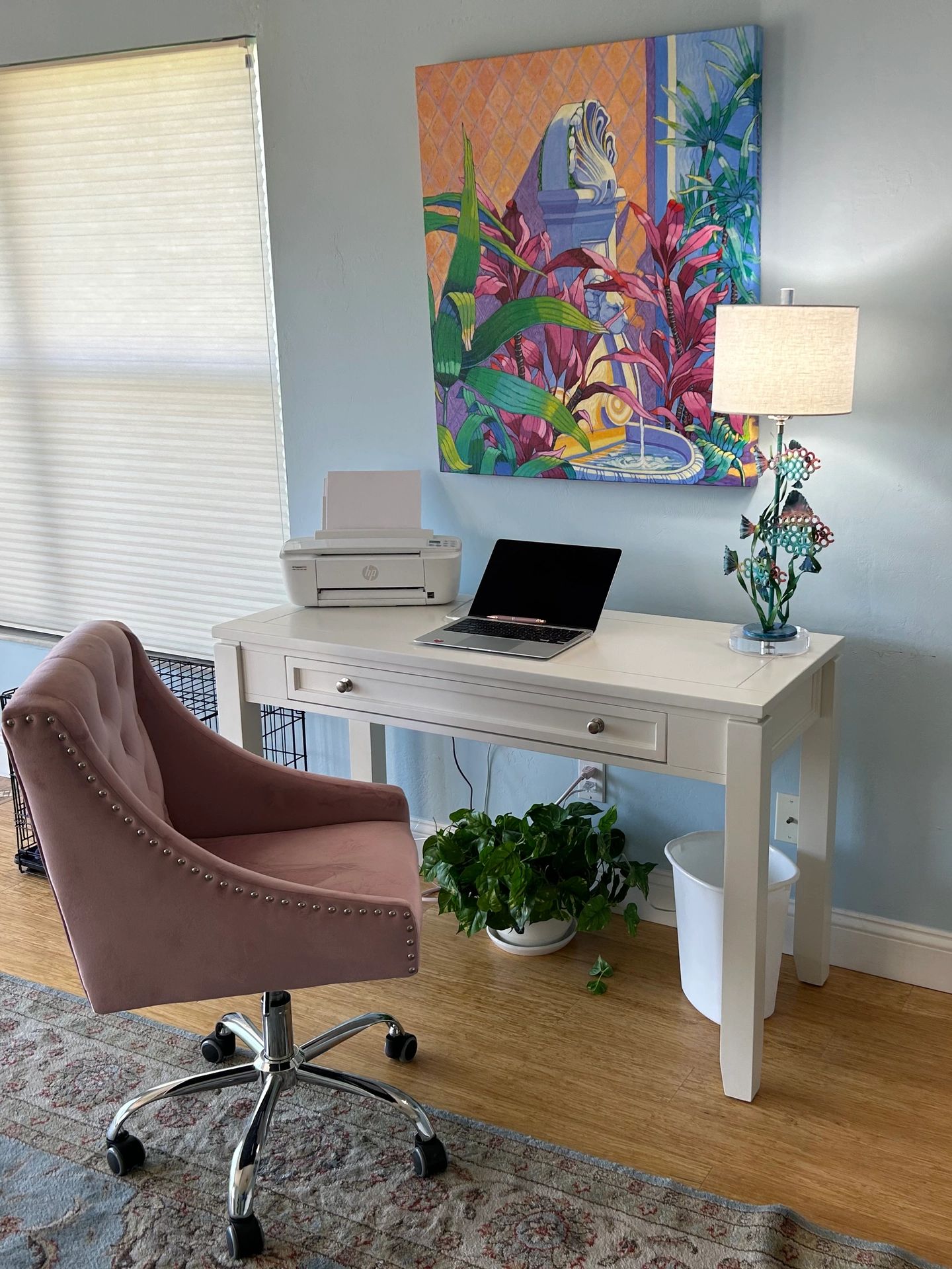 Cozy home office setup with a white desk and pink swivel chair.