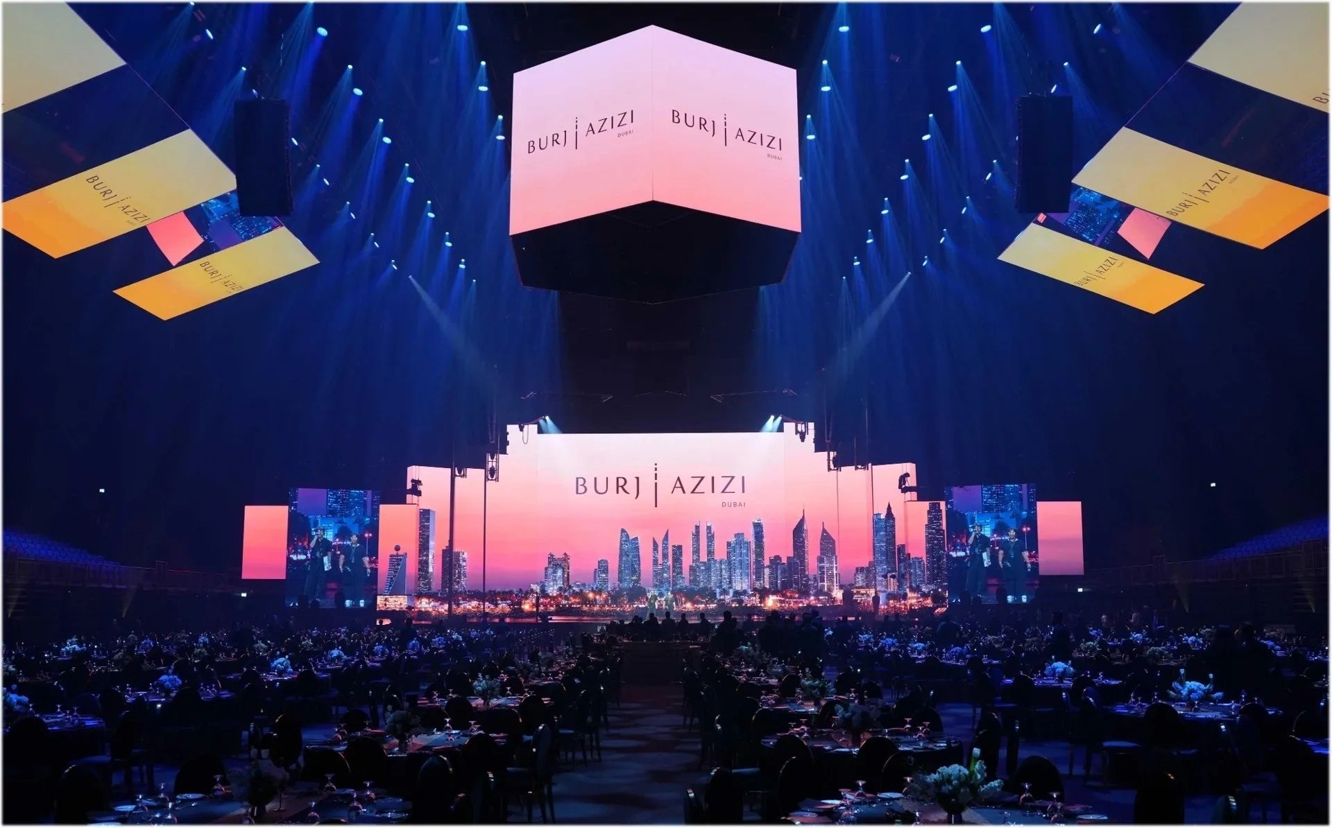 A large event stage with 'Burj Azizi Dubai' displayed on multiple screens.