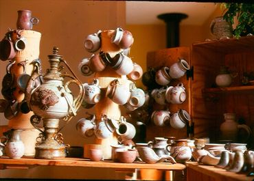 A collection of traditional ceramic teapots and cups displayed on shelves.
